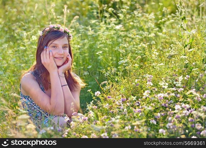 girl with wreath from flowers on field