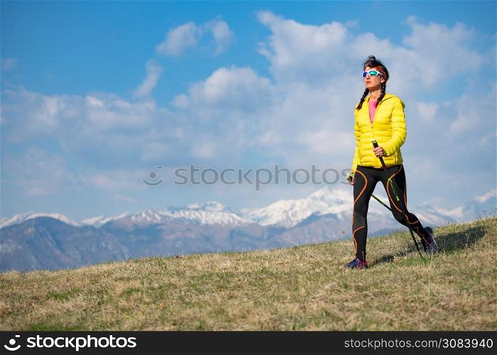 Girl with yellow down jacket strolls in the mountains