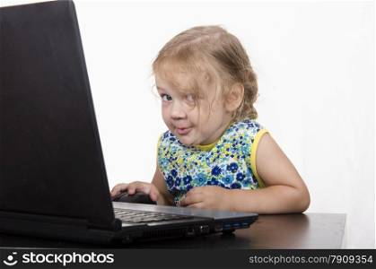 girl working at a laptop. Laptop stands on table. girl looked mysteriously in frame