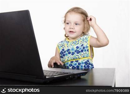 girl working at a laptop. Laptop stands on table. girl looked mysteriously in frame