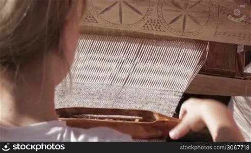 Girl working with traditional loom