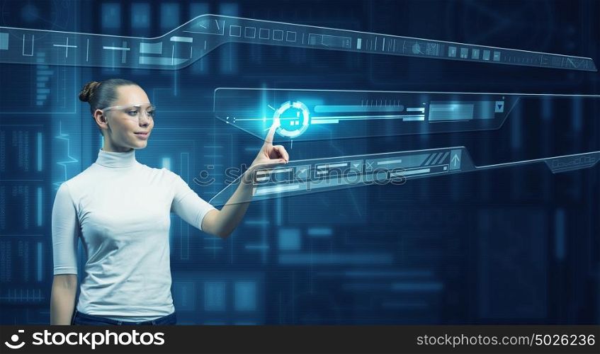 Girl working with virtual screen . Virtual holographic interface used by young pretty woman