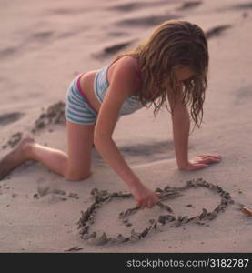 Girl writing in the sand on beach in Costa Rica