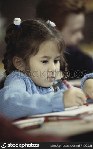 Girl writing with a crayon