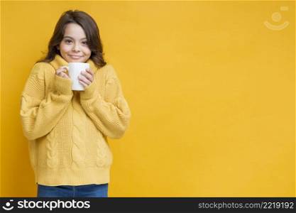 girl yellow sweater with cup hands