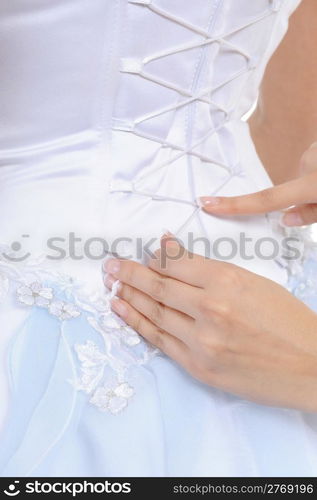 Girlfriend tightens karset bride. Isolated on white background