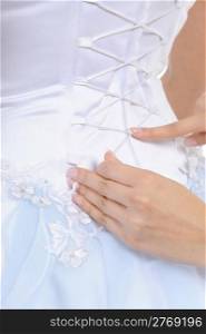 Girlfriend tightens karset bride. Isolated on white background
