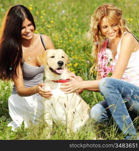 girlfriends and dog in green grass field