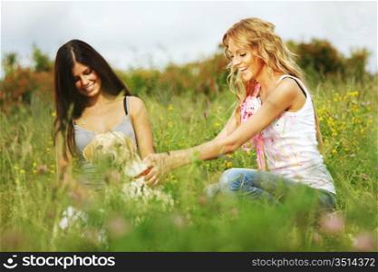 girlfriends and dog in green grass field