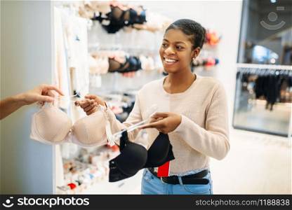 Girlfriends in dressing room, lingerie department, shopping. Shopaholics in clothing store, consumerism lifestyle, fashion, female shoppers in underwear section