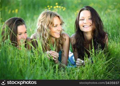 girlfriends lays on green grass and smile