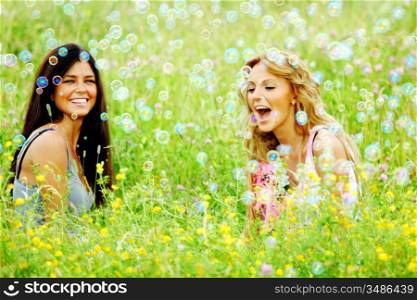 girlfriends on green grass field in soap bubbles