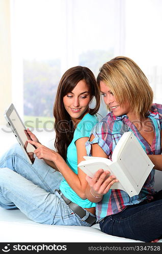 Girlfriends reading book on electronic pad