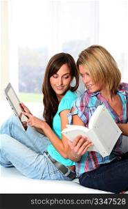 Girlfriends reading book on electronic pad