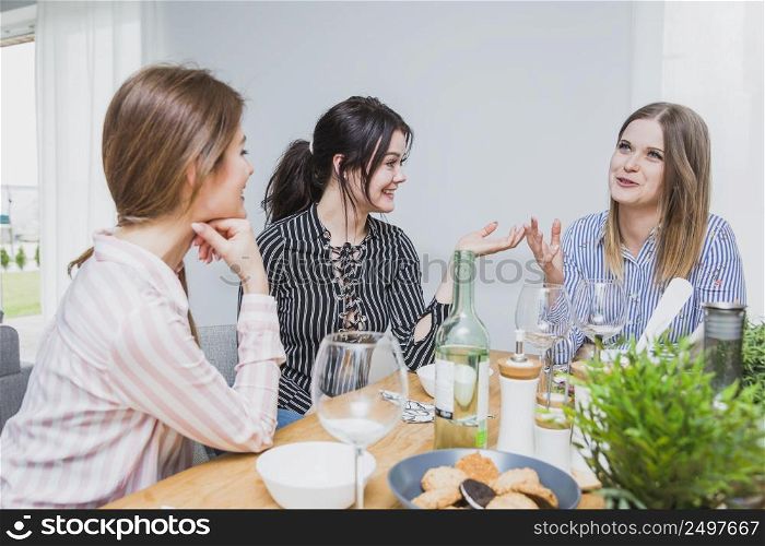 girlfriends sitting table chatting