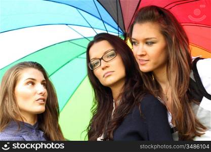 girlfriends stay under colourful umbrella