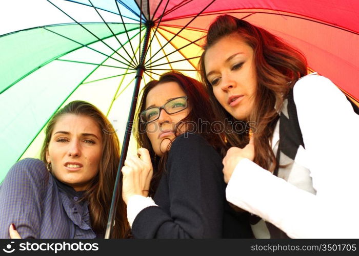 girlfriends stay under colourful umbrella