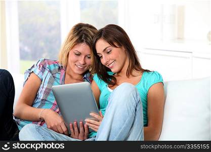 Girlfriends surfing on internet with electronic pad