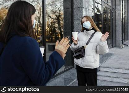 girlfriends wearing masks wave