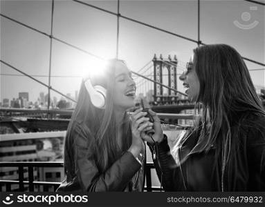Girls band girls singing in New York photomount. Best friends band girls singing karaoke outdoor at roof terrace in New York photomount