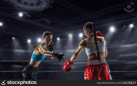 Girls boxing in ring. Two young pretty women boxing in ring