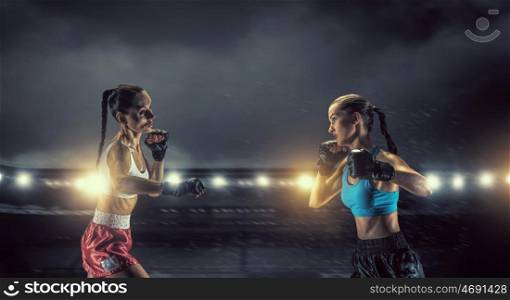 Girls boxing in ring. Two young pretty women boxing in ring