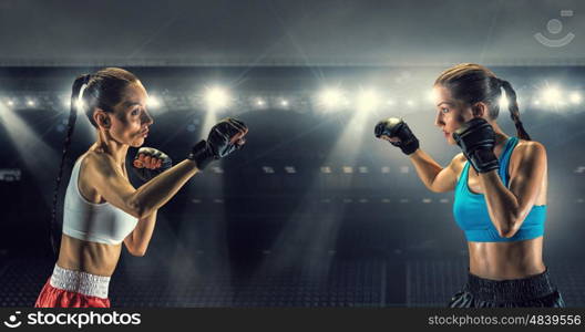 Girls boxing in ring. Two young pretty women boxing in ring