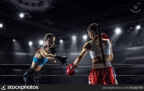 Girls boxing in ring. Two young pretty women boxing in ring