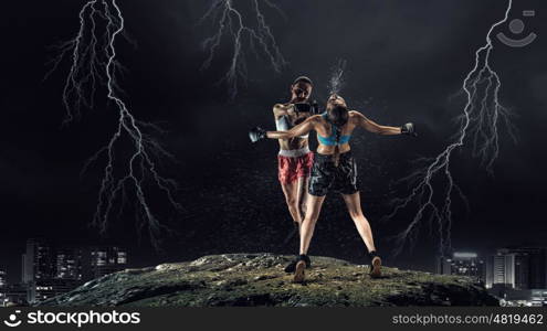 Girls boxing outdoor. Two young pretty women boxing against night city background