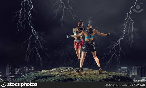 Girls boxing outdoor. Two young pretty women boxing against night city background