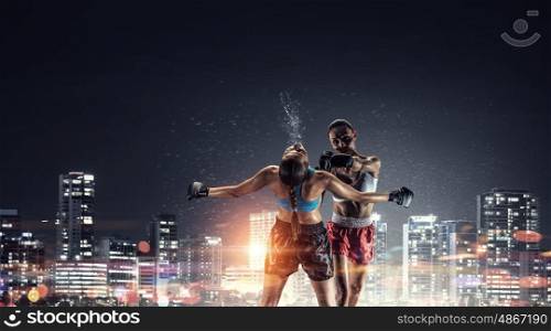 Girls boxing outdoor. Two young pretty women boxing against night city background