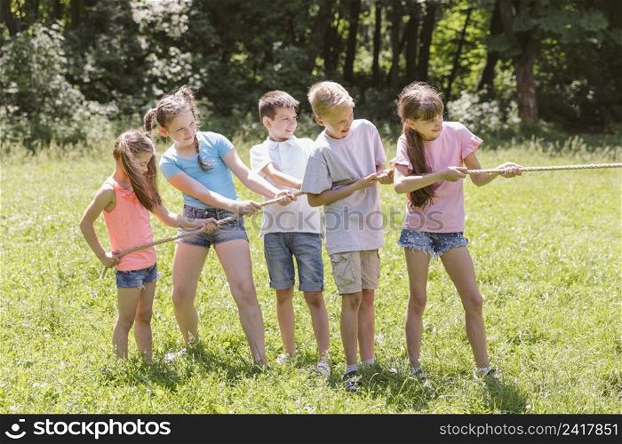 girls boys playing tug war