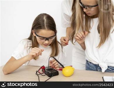 girls doing science experiments with female teacher lemon