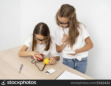 girls doing science experiments with lemon electricity