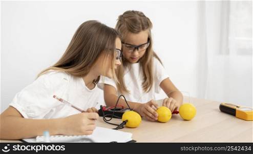 girls doing science experiments with lemons