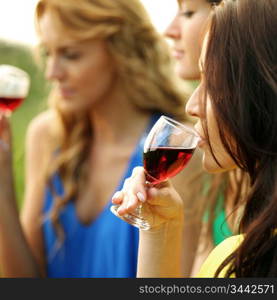 girls drink wine on nature background