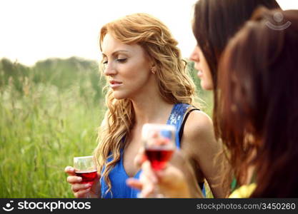 girls drink wine on nature background