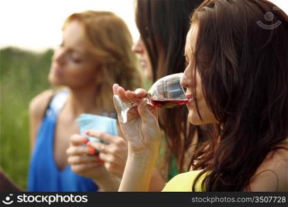 girls drink wine on nature background