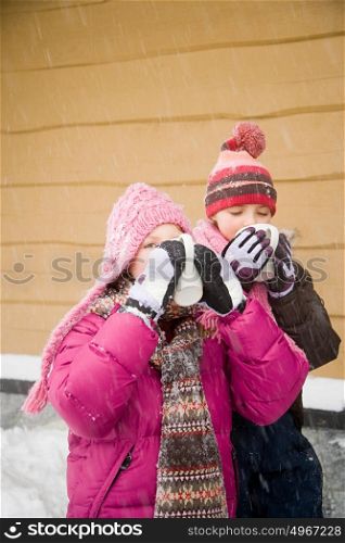 Girls drinking hot drink in snow