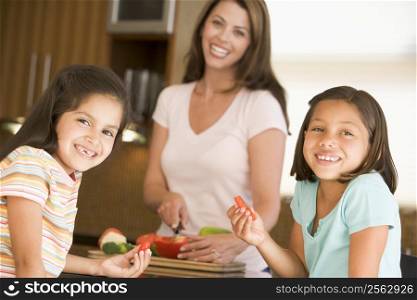 Girls Eating Pepper Strips While Mother Is Preparing meal,mealtime