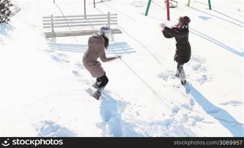 Girls having fun in snow in a citypark