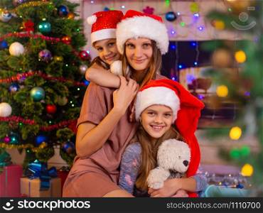 Girls hug their mother in the New Year&rsquo;s interior