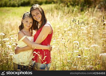 Girls hugging in tall grass
