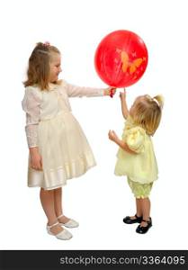 Girls in fancy dresses play with a red balloon.