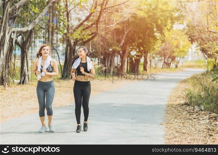 Girls jogging outdoor workout in the green park. Beautiful two Asian woman friend running outdoors.
