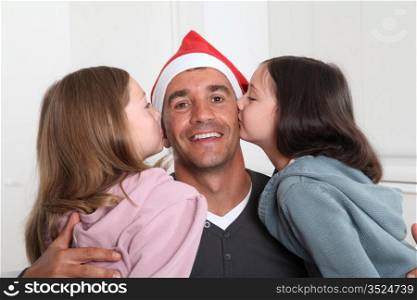 Girls kissing their father on Christmas day