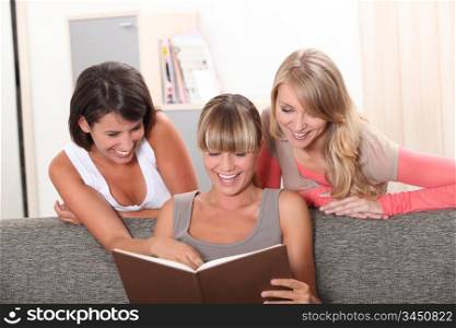 Girls laughing in front of a photo album