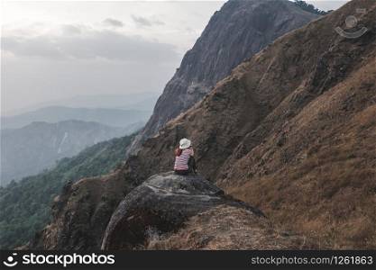 Girls like hiking red and white shirts sit on her back see the beautiful mountains At Mulayit Taung in Myanmar.