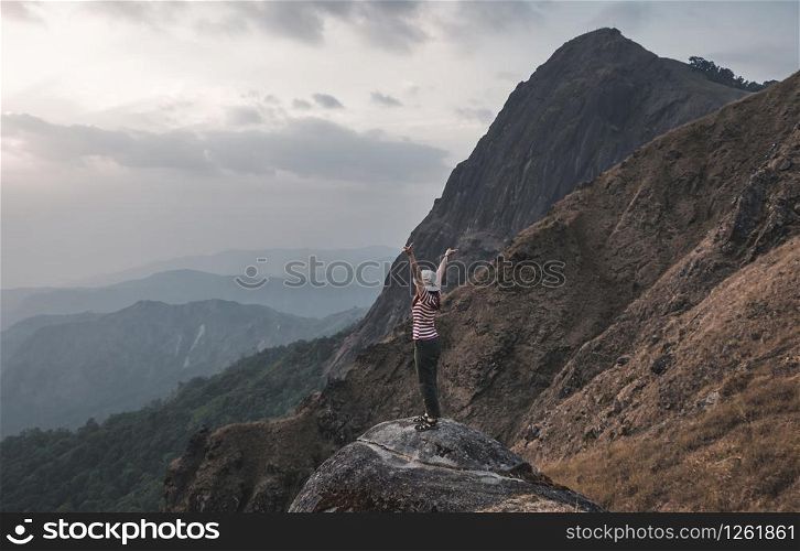 Girls like hiking red and white shirts standing on her back see the beautiful mountains, stretch out her hands naturally fresh. At Mulayit Taung in Myanmar.