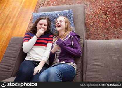 Girls lying on sofa giggling